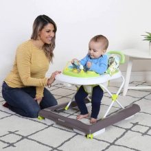 Image of a happy baby safely using a baby walker with caregiver's supervision in a childproofed environment.