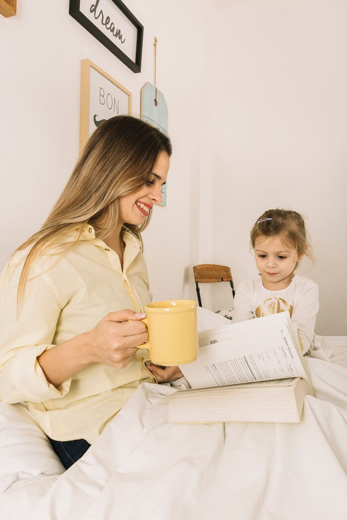 A parent taking a break and engaging in self-care activities, such as reading a book or enjoying a cup of tea, to prevent parental burnout.