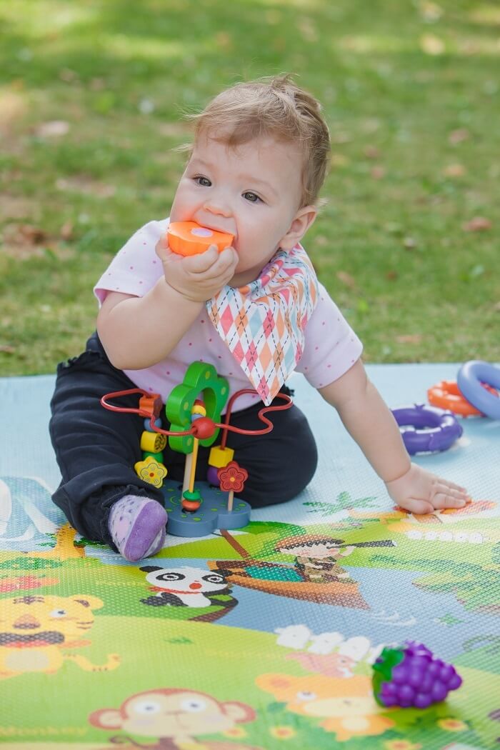 A 9-month-old baby during tummy time, lifting their head and actively exploring their environment, promoting physical development and motor skills.