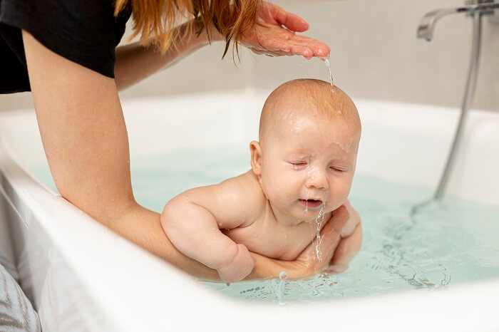 Caregiver giving a gentle bath to a newborn, ensuring hygiene and comfort