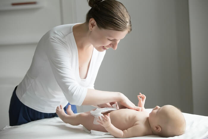 Caregiver changing the baby's diaper, an important aspect of newborn care