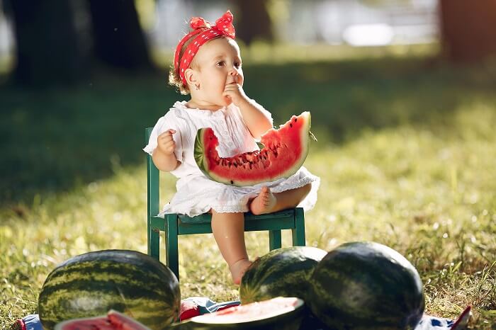 Baby playing with colorful fruits and vegetables