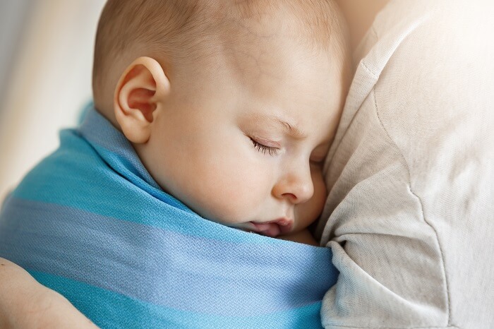 Newborn peacefully sleeping in a swaddle wrap, providing comfort and security