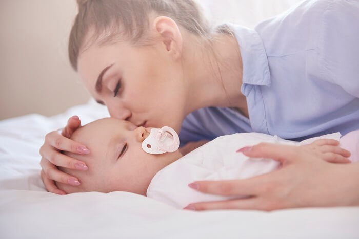 Parents soothing their newborn to sleep with gentle lullabies and a calming touch