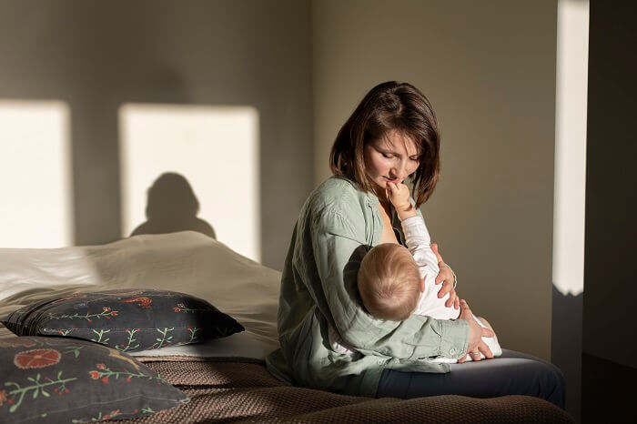 A tender moment between a mother and baby during breastfeeding, with soft lighting and a peaceful atmosphere.