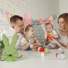 Image of toddlers celebrating Easter with colorful activities such as egg painting, egg hunting, bunny hop races, and crafts. The scene depicts a lively and joyful Easter Eggstravaganza for little hands.