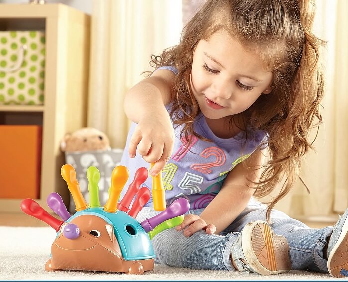 Baby Girl Exploring Learning Resources Fine Motor Hedgehog Toy.